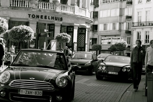 The street is bright, with cars and passers-by