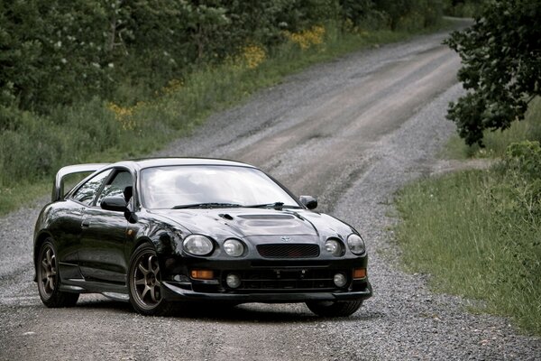 Samochód czarny Toyota Celica T200 GT-four stoi na polnej drodze