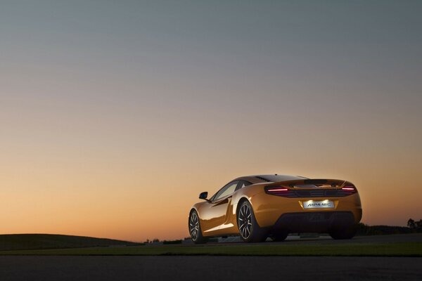 Yellow car behind on sunset background