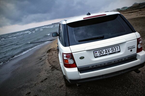 Voiture blanche conquiert la côte de la mer