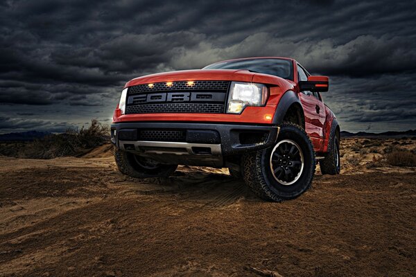 Ein leuchtend rotes Ford technologisches Auto auf einem Hintergrund von Wolken