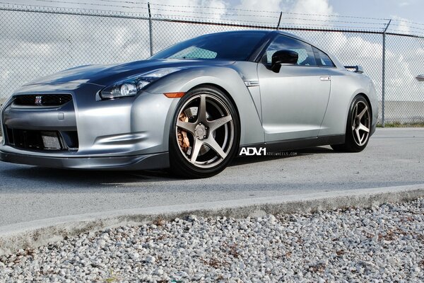 A silver-colored car is standing on the asphalt