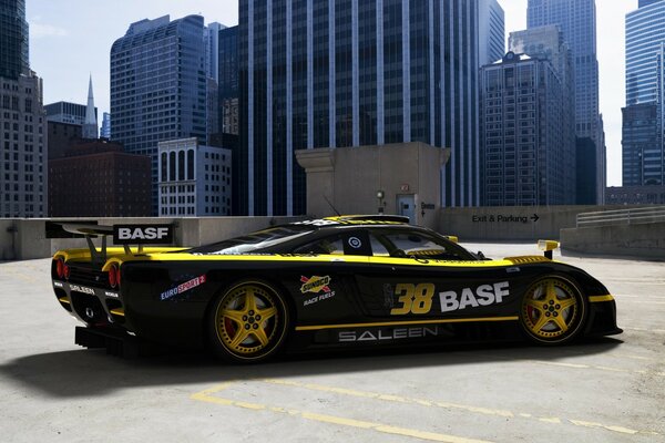 Black sports racing car on the background of tall buildings