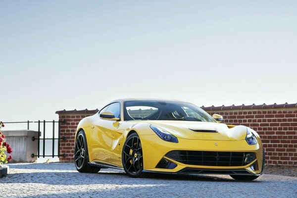 Yellow car on the background of a fence