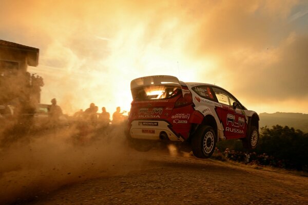 Carro de corrida no deserto em meio ao pôr do sol