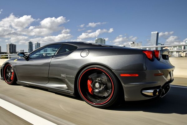 Photo of a sports car with red and black wheels on wheels