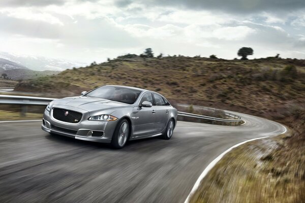 A silvery new car is racing along the highway