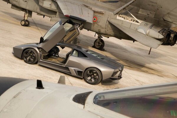 A car with its doors open up against the background of an airplane