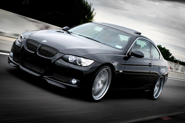 A black BMW rushes along the autobahn