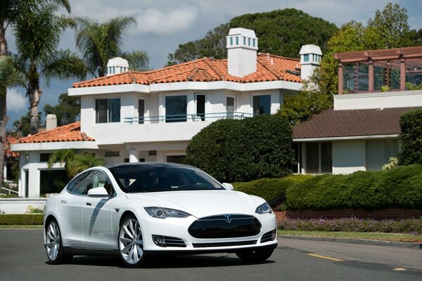 A white car on the road among the houses