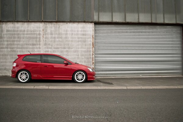 Hatchback rojo en el ciclo suburbano