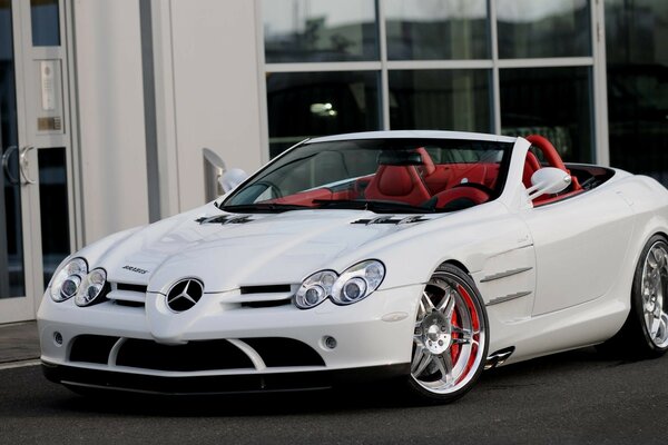 A white luxury car with a red interior