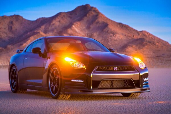 Car with headlights on the background of mountains