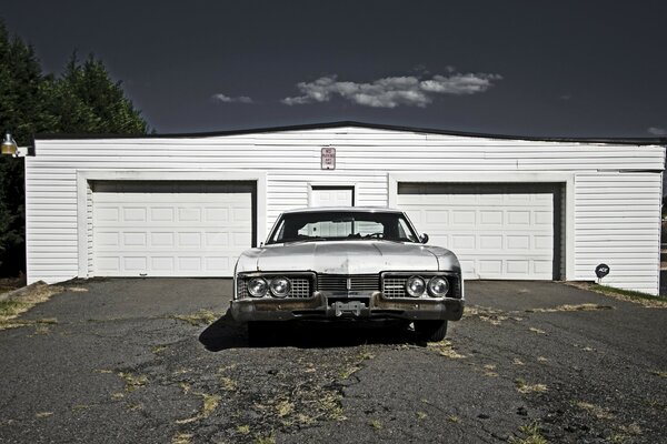 Grey retro car near garages