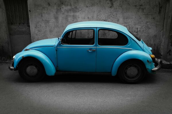 Blue retro car by the wall