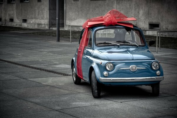 Pequeño coche azul con lazo de regalo