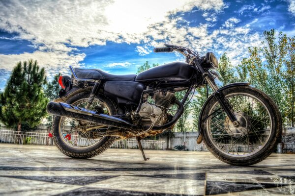 The motorcycle stands on a sparkling background