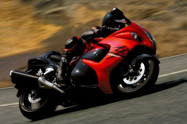 Foto de una moto con un piloto en viraje