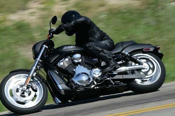 A biker on a black motorcycle enters a turn