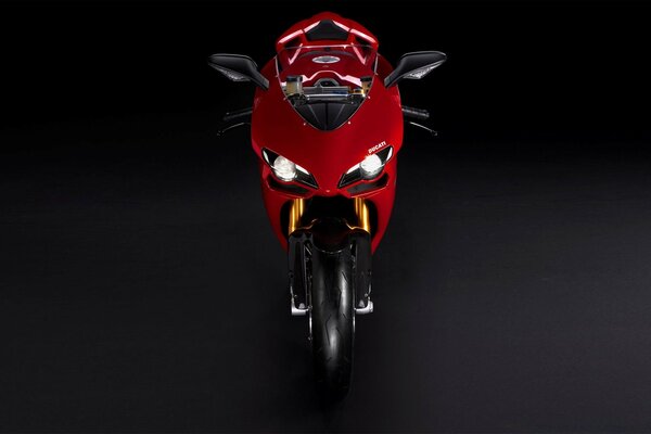 A red wound-up motorcycle on a black background