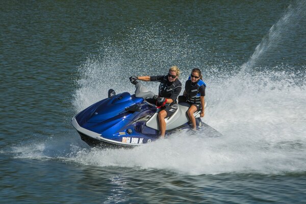 Zwei Personen fahren auf einem blauen Jetski