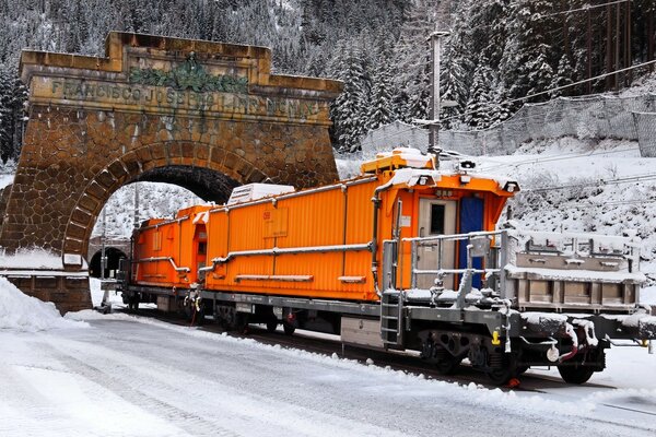 Orange locomotive rides through the arch