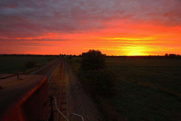 Chemin de fer dans un champ au coucher du soleil