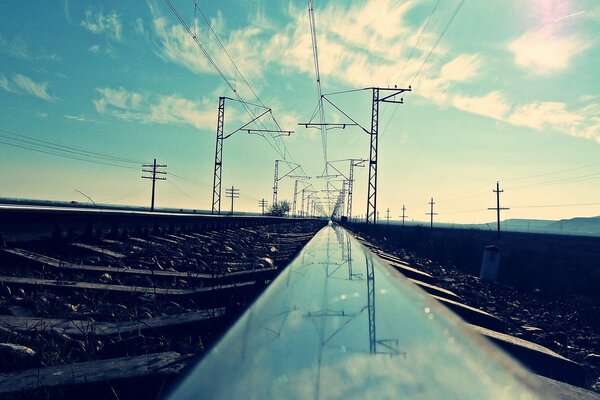 The polished rails reflect the sky