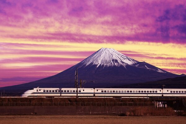 Tren de alta velocidad en movimiento en el fondo de una gran montaña