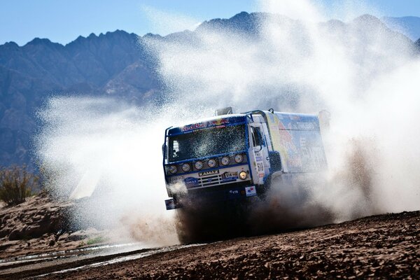 La máquina KAMAZ persigue un enorme charco y crea un chapoteo de agua