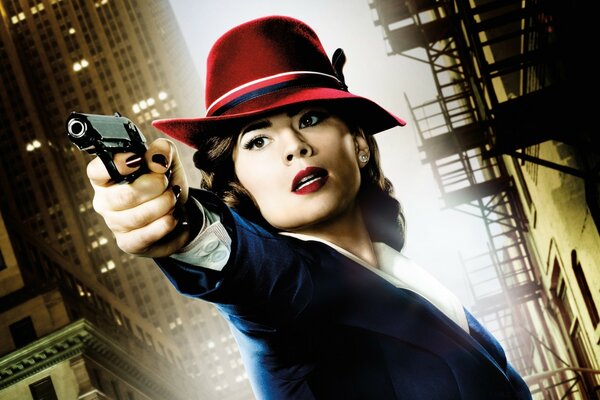 A woman in a red hat with a gun