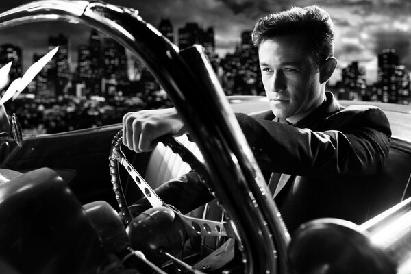 Black and white portrait of a man driving a convertible