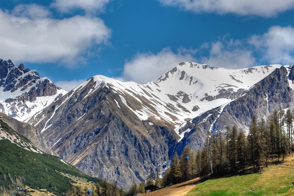 A combination of snow-covered and green mountains