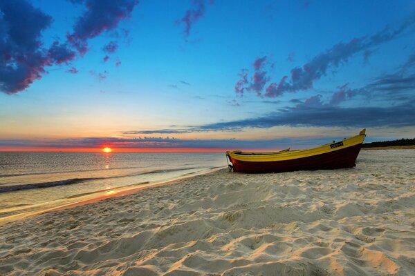 Bateau sur le sable au bord de la mer