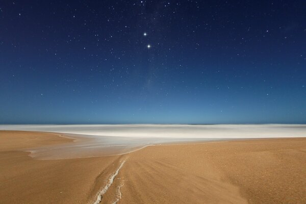 Ciel étoilé sur la mer et le sable