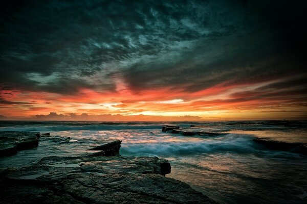 Tramonto cupo sulla costa rocciosa