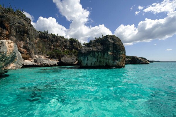 Eau bleue près des rochers avec des nuages dans le ciel