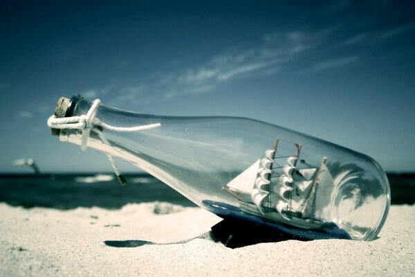 سفينة في زجاجة على شاطئ البحر