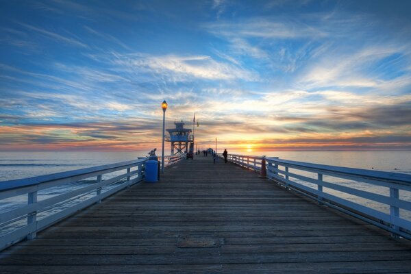 Langer Pier auf dem Wasser bei Sonnenuntergang