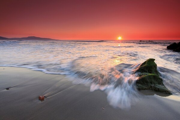 Hermosa puesta de sol junto al océano en la playa