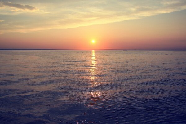 A beautiful sunset is reflected in the dark water