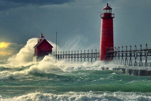 Red lighthouse in the sea with waves