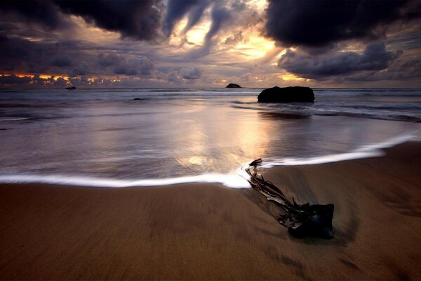 Der Sandstrand des Ozeans und die sich verdickenden Wolken