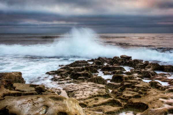 موجة على شاطئ المحيط الصخري