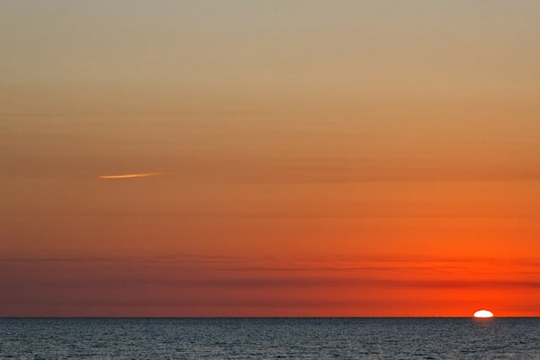 Leuchtend rote Morgendämmerung am Meer