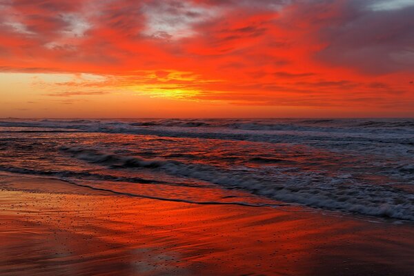 Amanhecer vermelho envolve o oceano