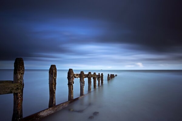 Ancienne jetée se dissolvant dans la mer bleue