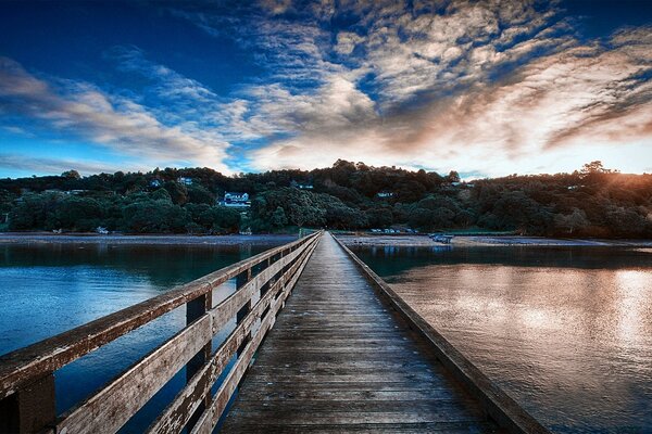 Puente de madera sobre el río al atardecer