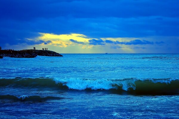 Puesta de sol en un mar no tranquilo. La ola que se aproxima