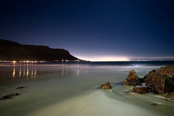 Sandy beach near the city at sunset